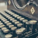 Joven pareja revisando un presupuesto familiar en una mesa con cuaderno y portátil