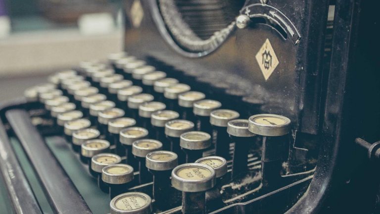 Joven pareja revisando un presupuesto familiar en una mesa con cuaderno y portátil