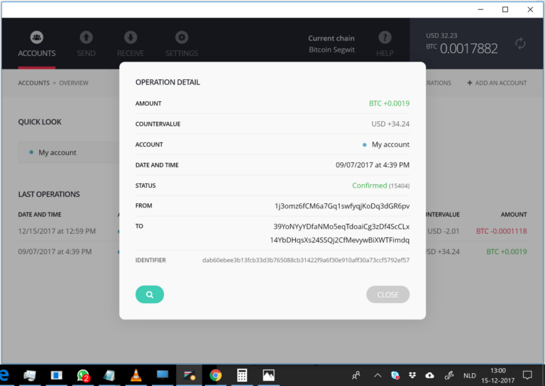 Monedero físico para criptoactivos conectado por cable a un ordenador portátil sobre una mesa
