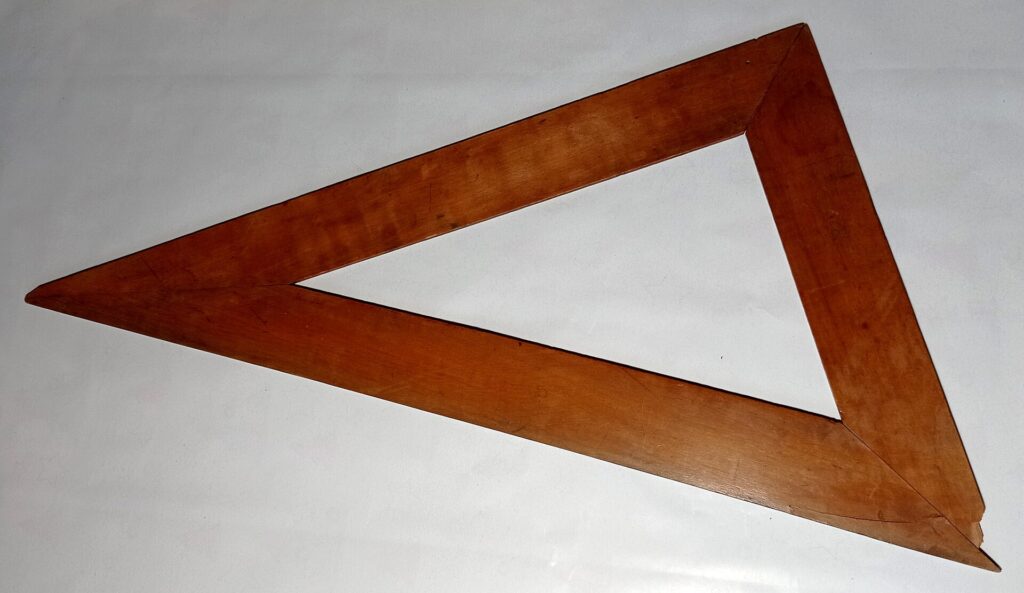Regla de madera graduada junto a un lápiz afilado sobre una hoja cuadriculada en blanco