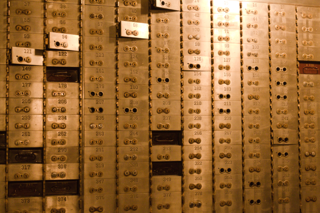 Pared de cajas de seguridad numeradas con cerradura doble en el interior de un banco