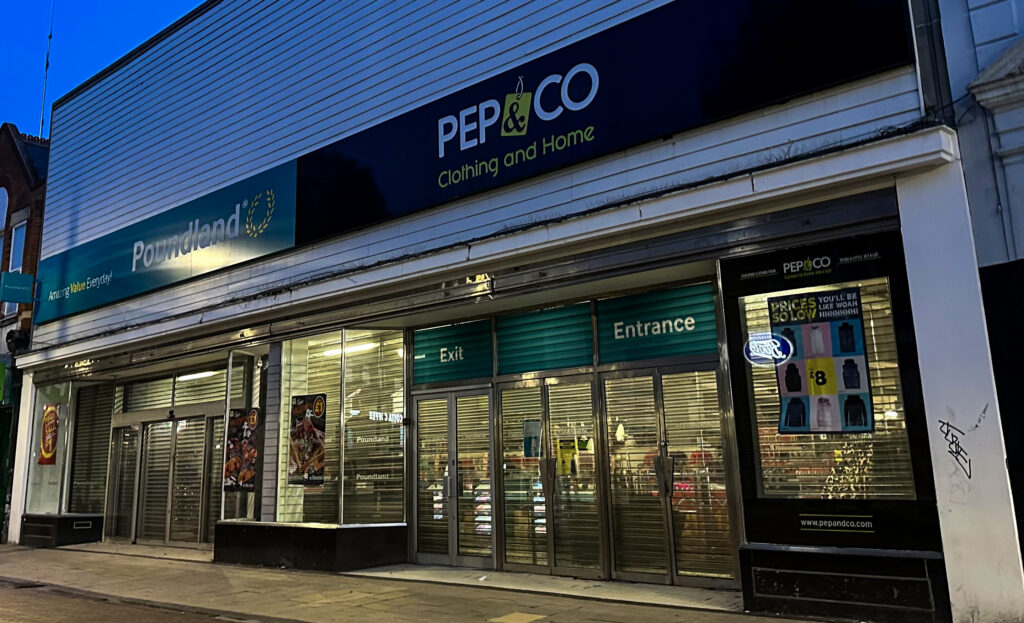 Persiana metálica bajada de un local comercial cerrado en una calle vacía