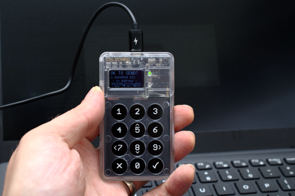 Dispositivo de monedero f&iacute;sico para criptoactivos conectado a un cable USB