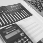 Calculadora junto a un montón de tiques y facturas apilados sobre una mesa de oficina