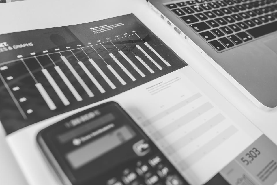 Calculadora junto a un montón de tiques y facturas apilados sobre una mesa de oficina