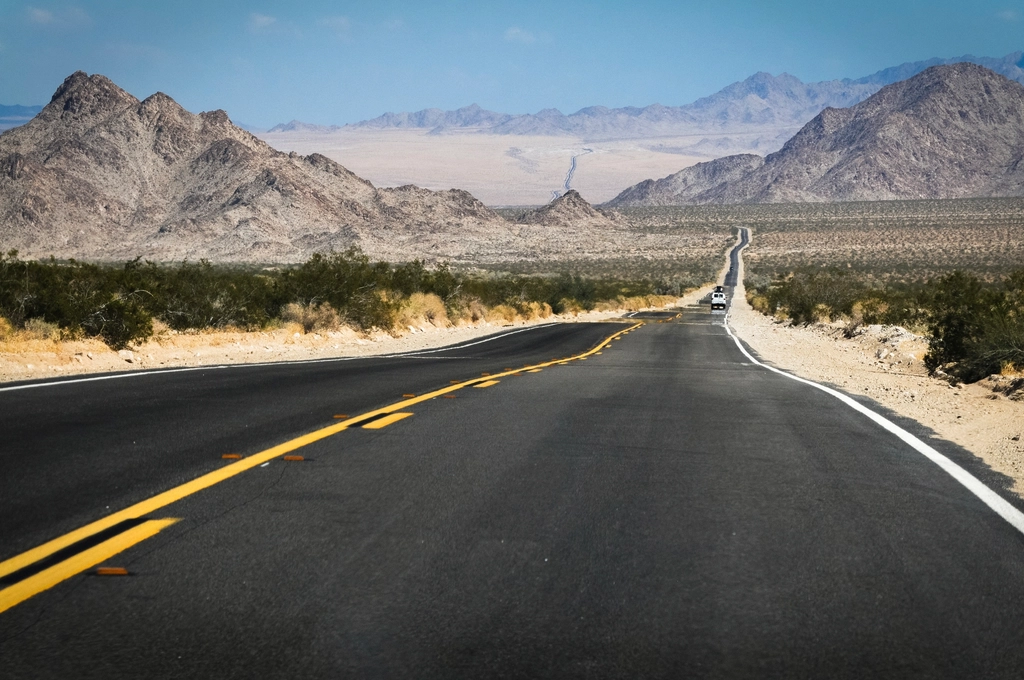 Carretera recta y vacía que se pierde en el horizonte bajo un cielo despejado