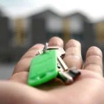 Llaves de una vivienda sobre un contrato hipotecario junto a una calculadora en una mesa