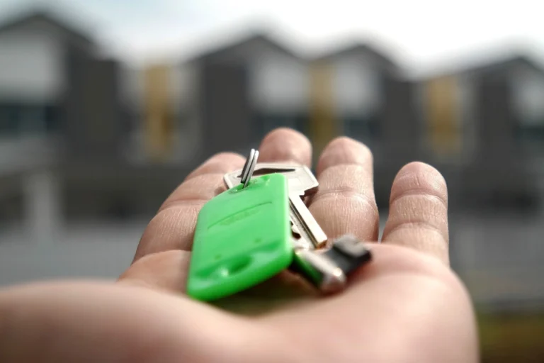Llaves de una vivienda sobre un contrato hipotecario junto a una calculadora en una mesa