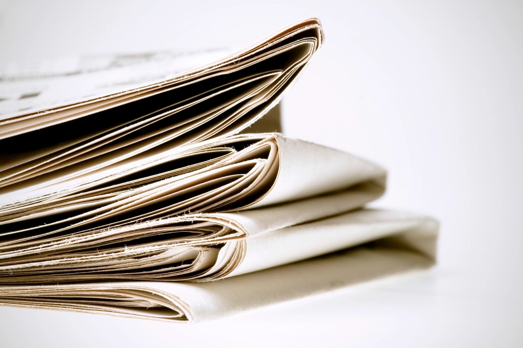 P&aacute;gina de econom&iacute;a de un peri&oacute;dico impreso con tablas de cotizaciones y titulares